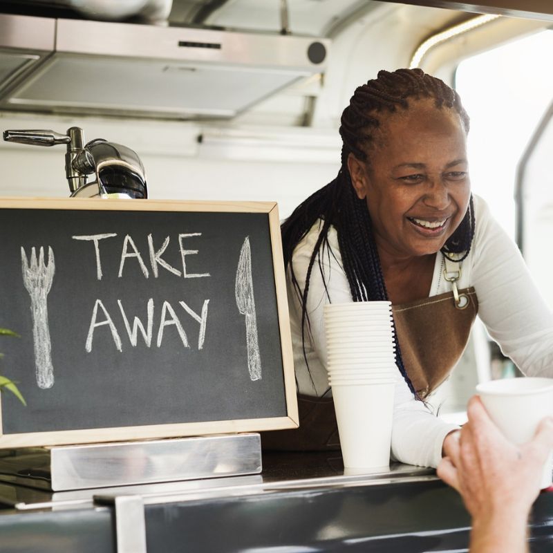Senior Black woman serving customers at a food truck